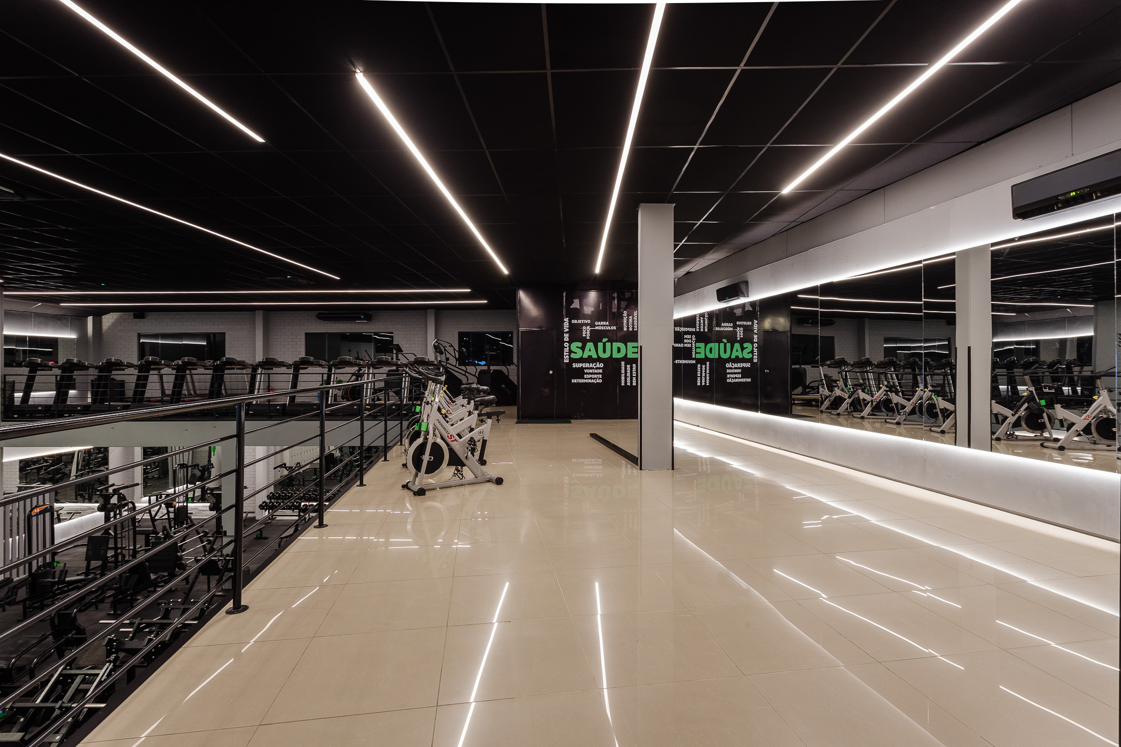 Área de cardio no piso superior com bikes de spinning e esteiras