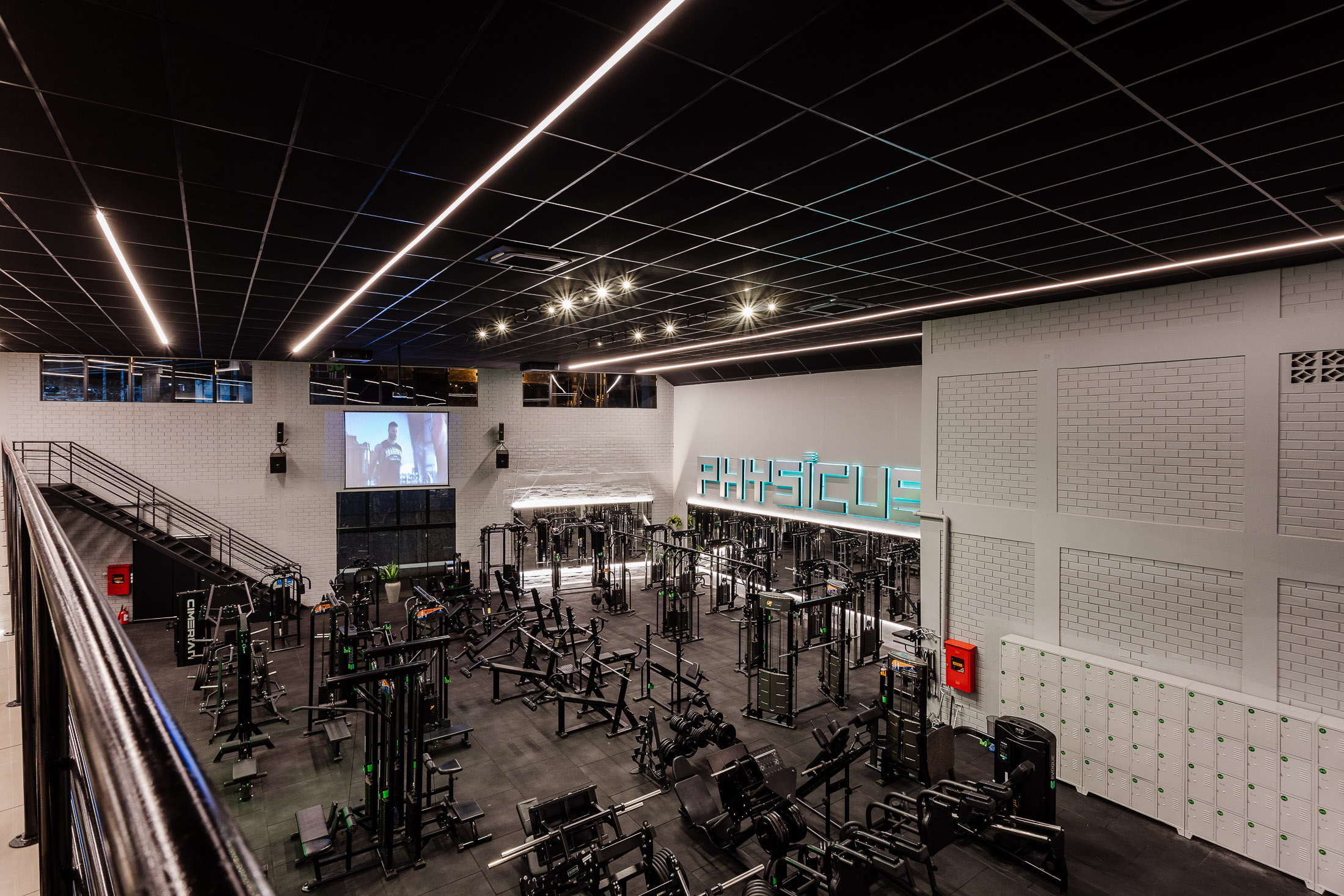 Visão geral do salão de musculação com telão